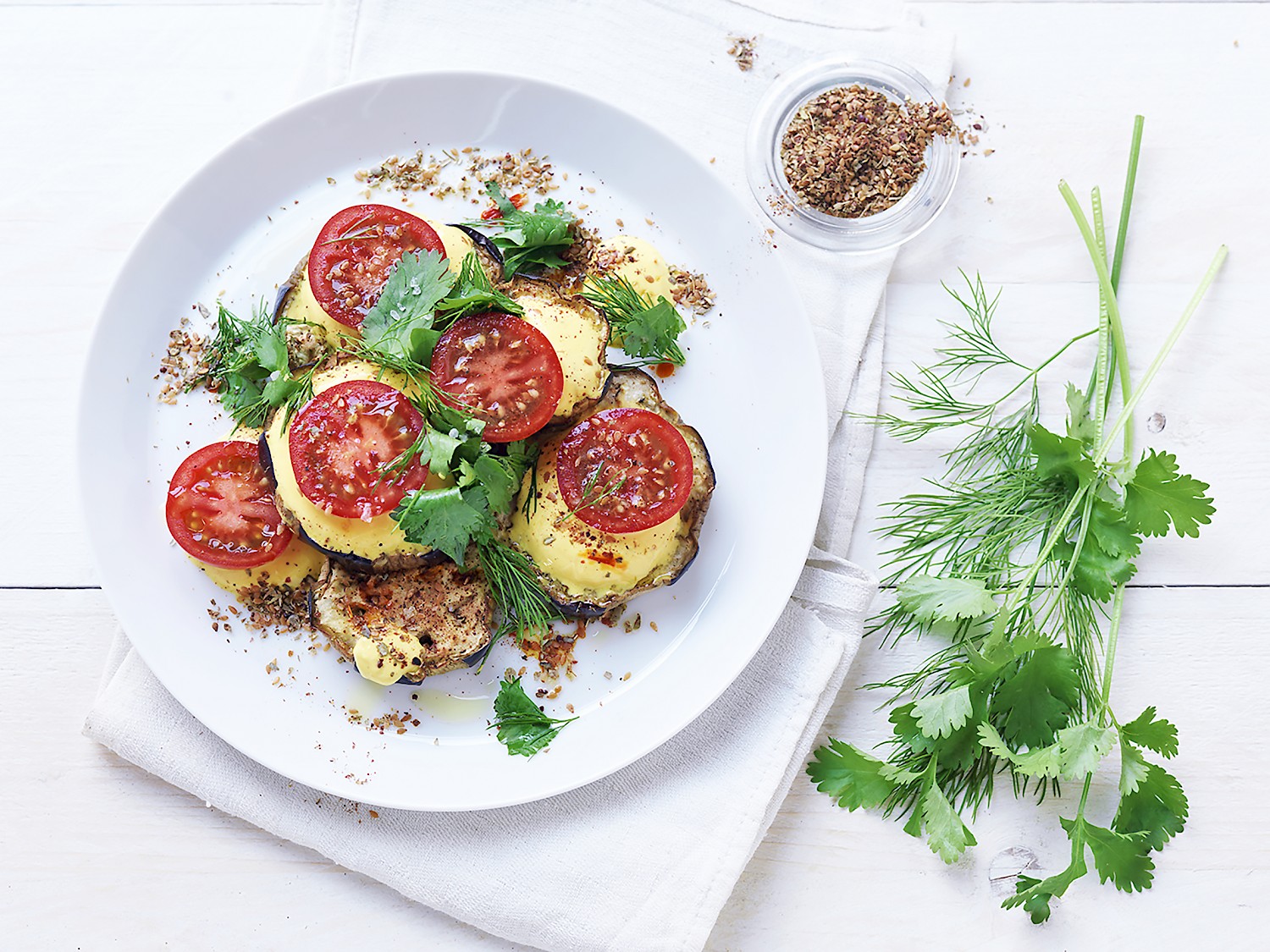 Cocktailtomaat met geroosterde aubergine, saffraanyoghurt, verse kruiden en Za'atar